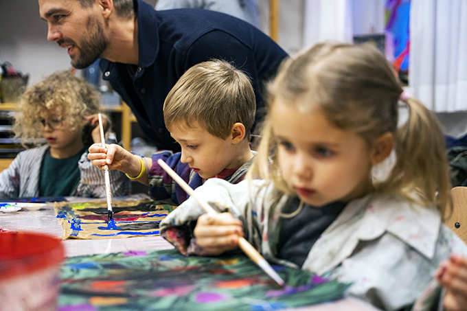 Barn och vuxna skapar konst tillsammans i verkstaden.
