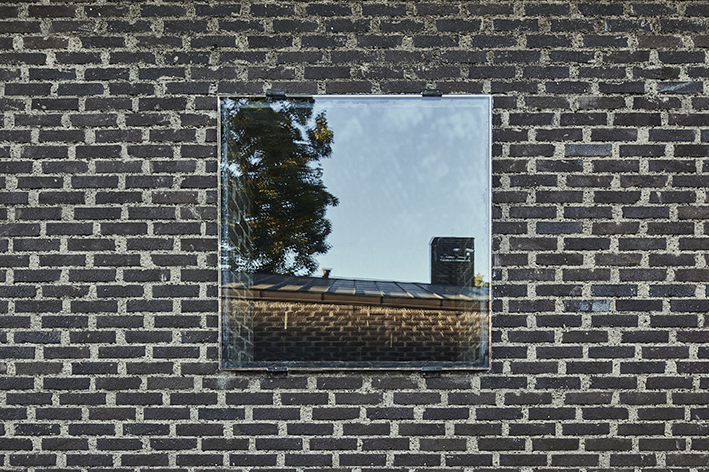 Ett fönster på mörkbrun tegelfasad, S:t Petri Kyrka i Klippan.