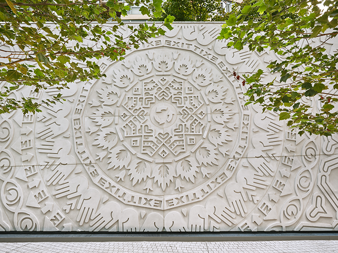 tt kalejdoskopiskt mandala-liknande mönster av symboler på en stor betonggjutning.