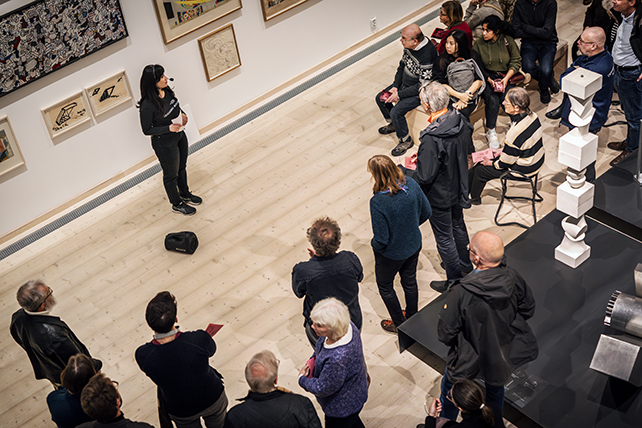 En grupp människor i halvcirkel uppifrån. De är vända mot en person som pratar i mitten.
