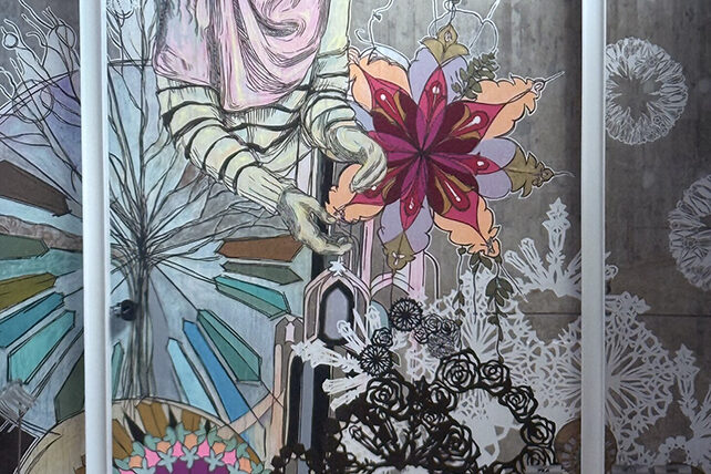 Människor sitter i en halvcirkel och betraktar ett stort väggkonstverk.