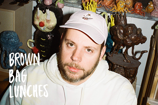 Porträtt Joakim Ojanen iklädd vit keps och vit hoodie. I bakgrunden keramikskulptur.